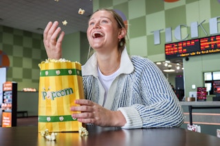 a person throwing up popcorn in a movie theater lobby