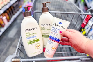 hand holding aveeno lotions in a shopping cart