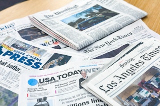 a stack of sunday papers on a table