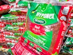 A bag of red Scotts Hyponex mulch in Walmart shopping cart