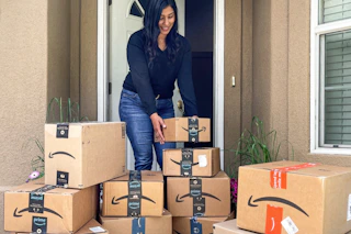 woman with amazon boxes piled by door