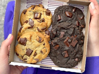 graduate holding a six-pack box of free insomnia cookies