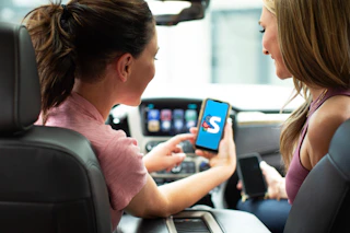 Two people in a car looking at the Shopkick app on a mobile phone.
