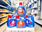 four bottles of persil detergent on laundry basket in walmart aisle