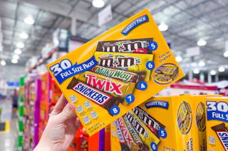 hand holding a box of mars candy bars