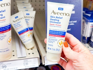 hand holding aveeno healing ointment in front of a target shelf