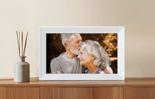 a grey digital picture frame on a wooden dresser
