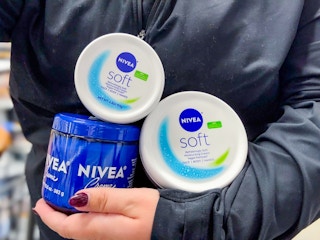 Three Nivea products being held be someone in Walmart store (close up shot) 