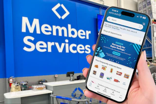 someone holding up their phone showing the sams club app in front of the member services desk