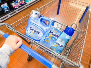 hand pushing walmart cart with three blue sparkle snuggle 