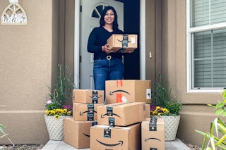 a woman standing on her front porch surrounded by amazon boxes